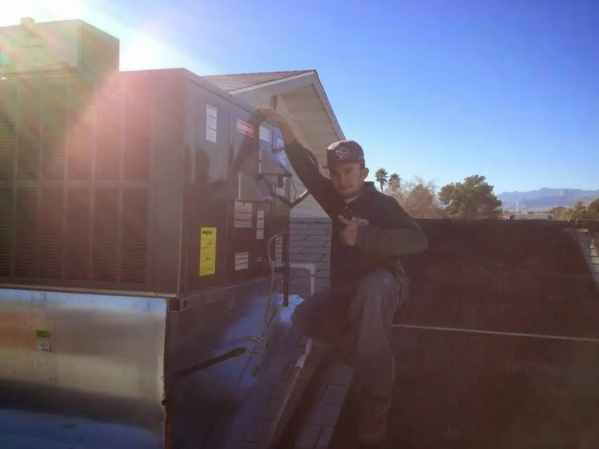 HVAC technician performing Air Duct Cleaning on a rooftop unit in Waynesville